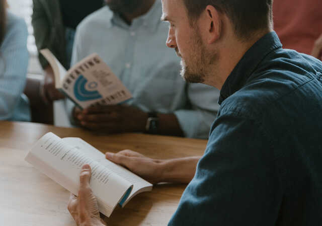 men reading a book together