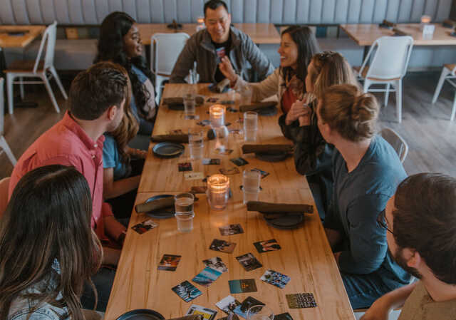 diverse group of people talking at a table in a restaurant