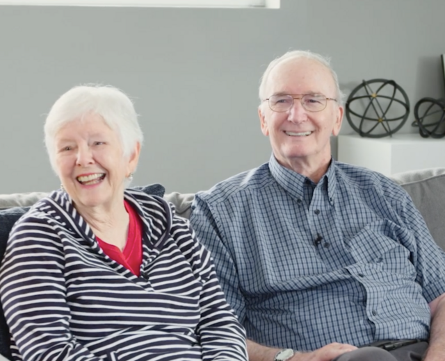 older couple sitting on sofa smiling
