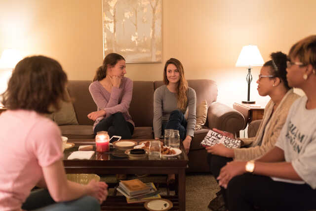 women in a community group having a discussion in a living room