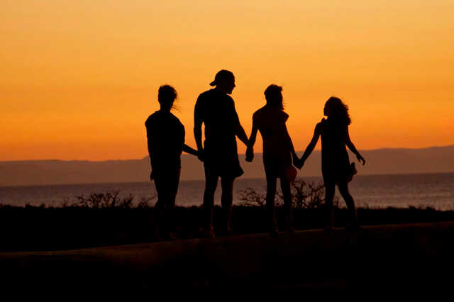 family holding hands at sunset