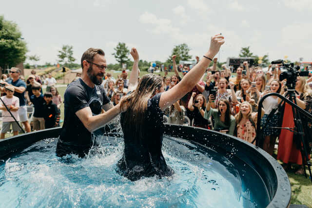 woman coming out of the water after baptism and crowd celebrating